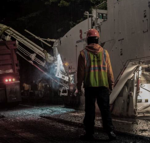 Perosnale al lavoro sul impianto di bitume
